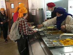 Receiving Langar, the free vegetarian meal Sikh Gurdwaras must provide daily, depending on their size